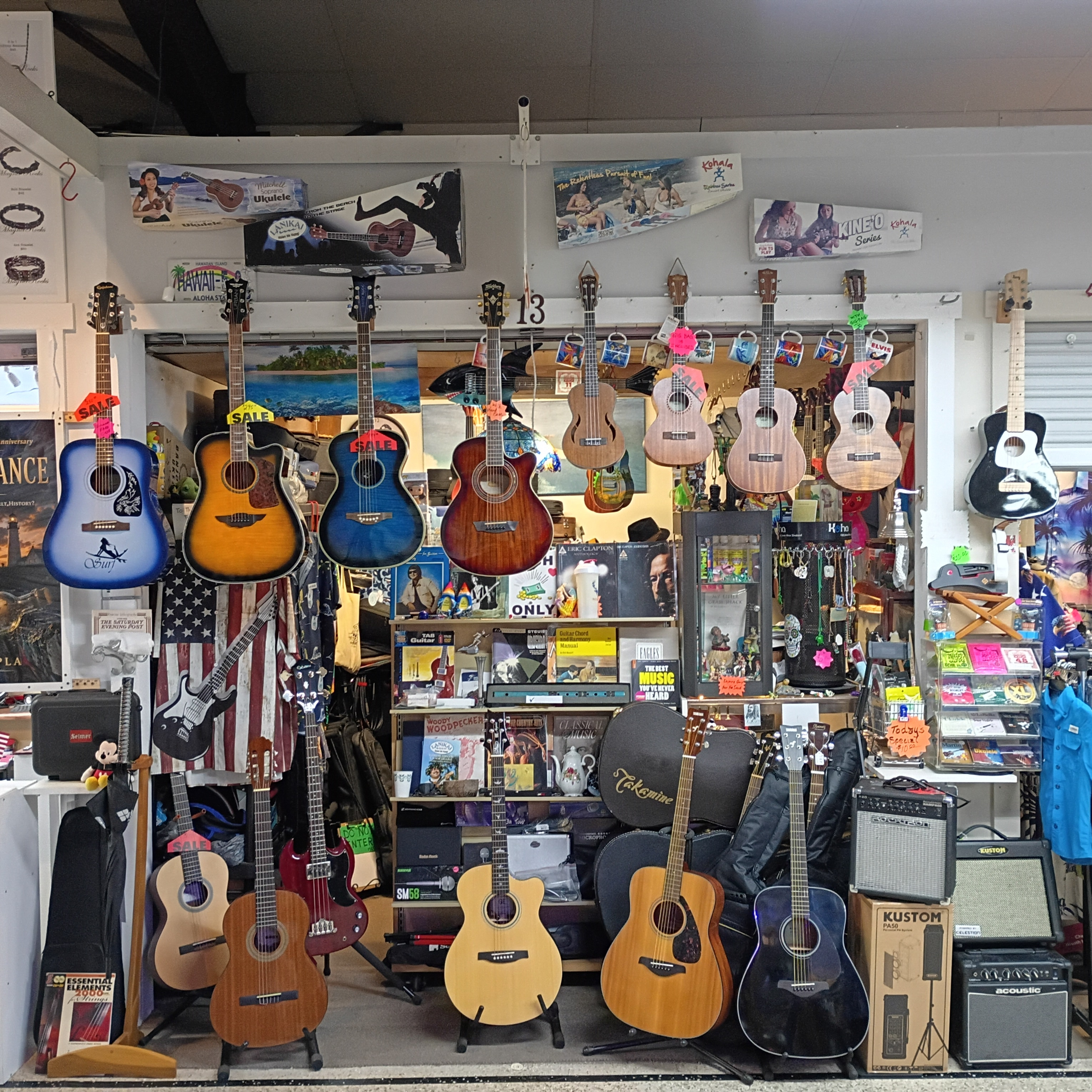Ukuleles and acoustic guitars displayed beneath the Guitar Stan sign inside Aloha Daytona Beach.